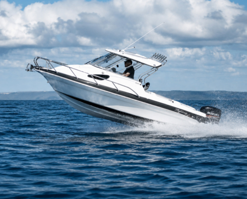 bg-right2 | ALFAB Australia White motorboat speeding across blue water, with a person at the helm and a Suzuki outboard engine visible.